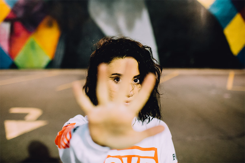 Our example image of a woman holding up her hand to indicate