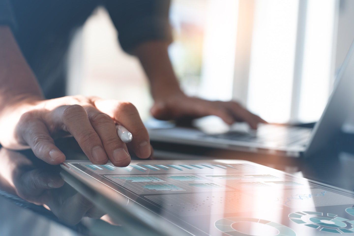 Person using tablet to look at sales data and charts