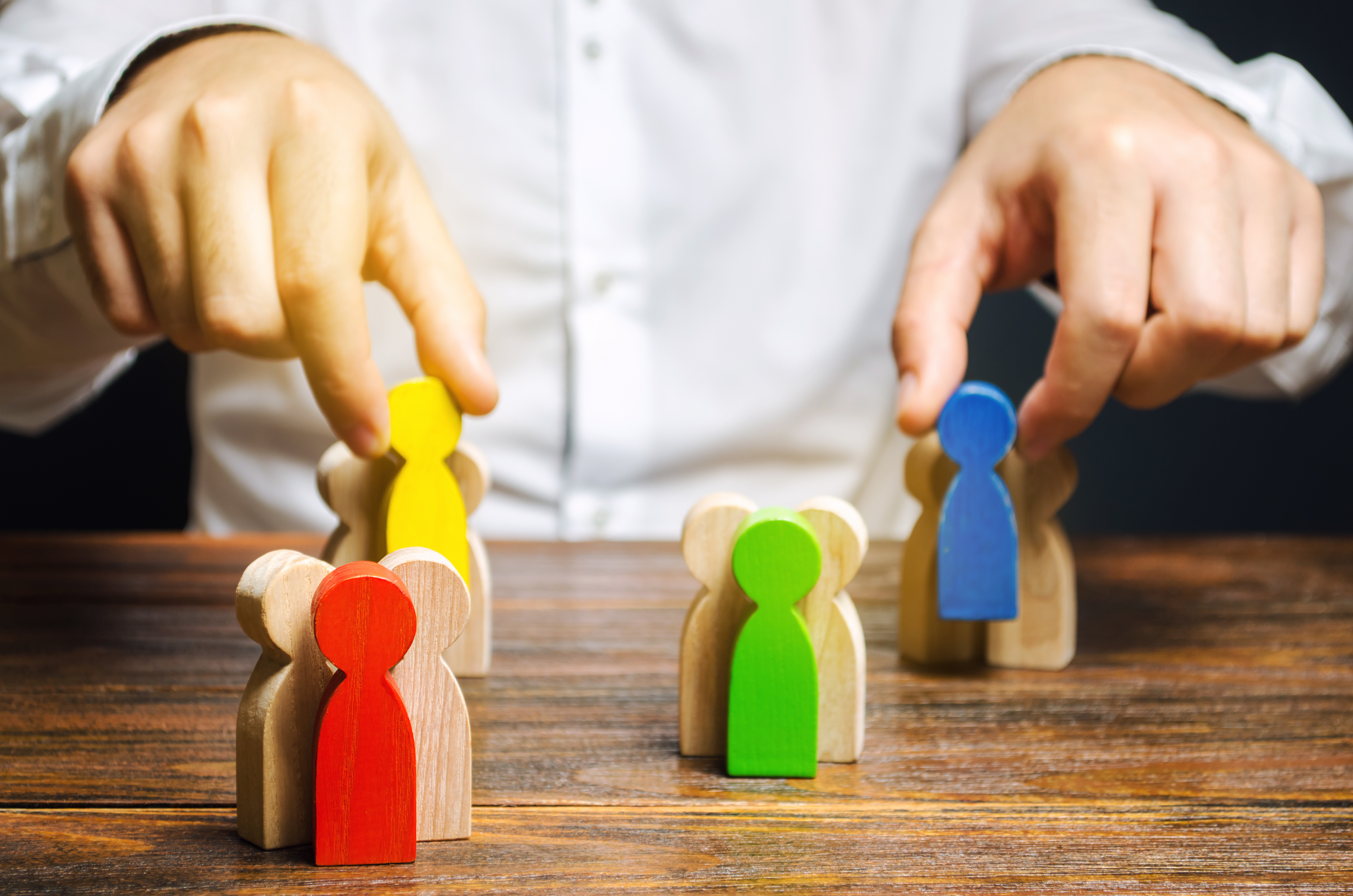 groups of multicolored wooden people and businesspeople